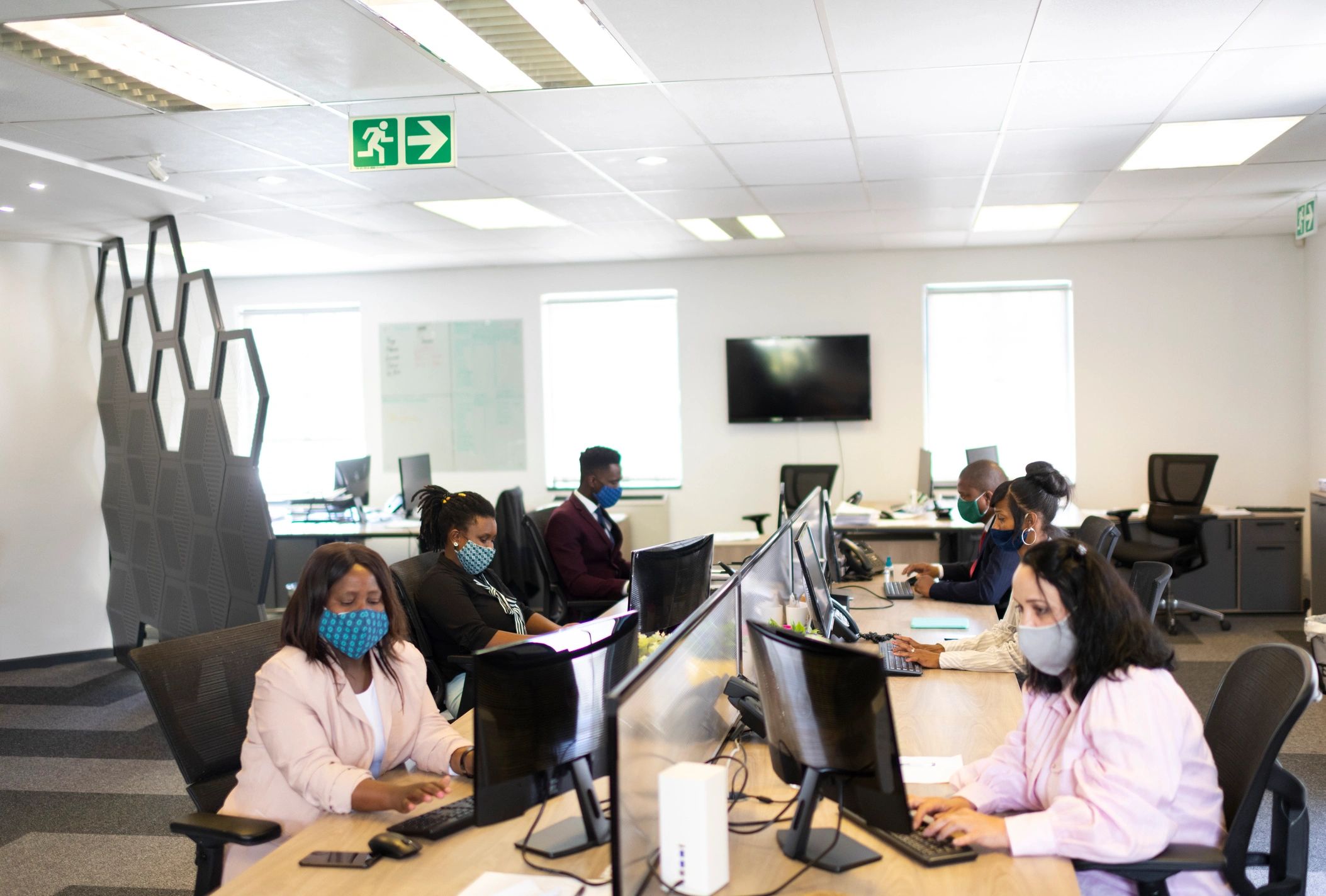 Corporate office team working across desks in a professional environment